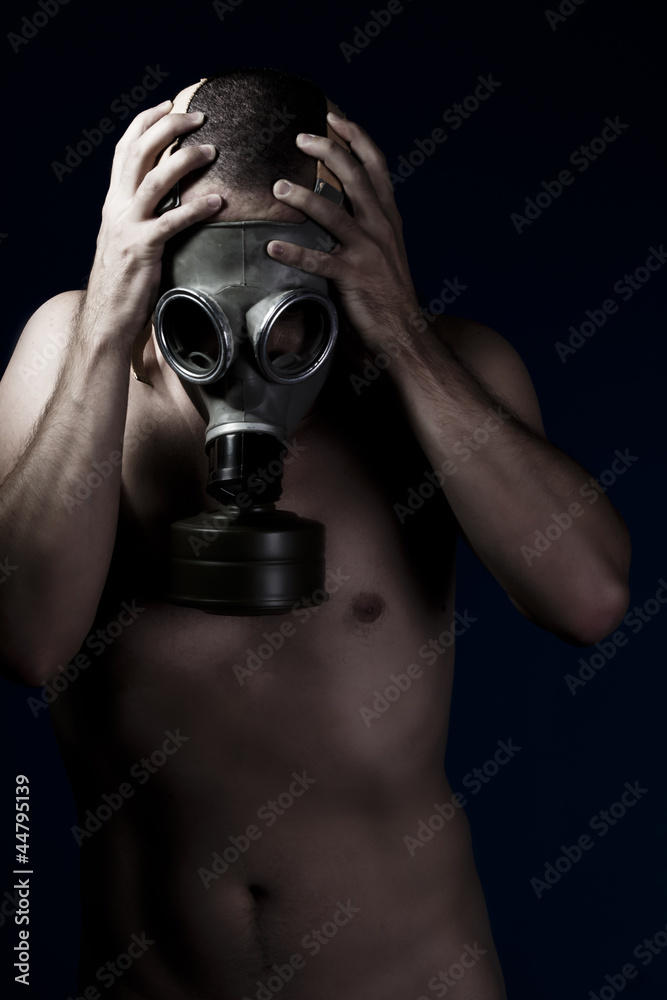 Terror, handsome man with bare torso and gas mask