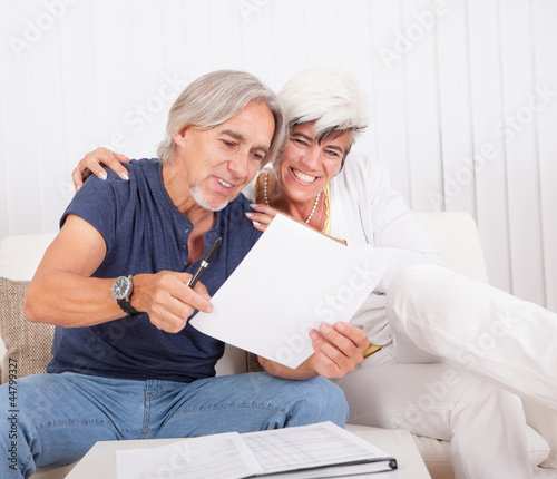 Excited middle-aged couple reading document