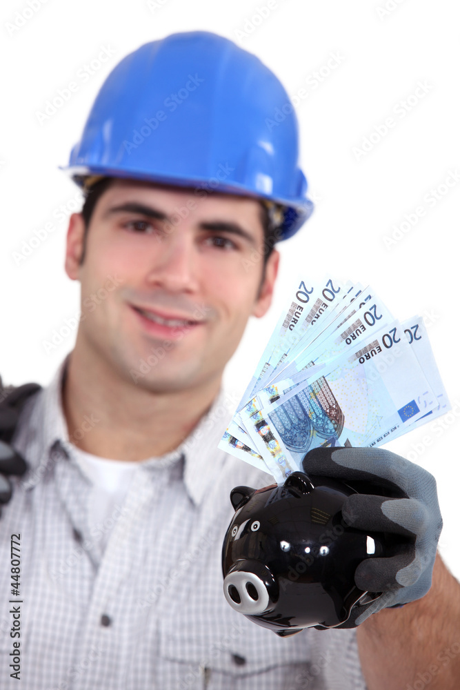 portrait of young foreman holding bills and piggy bank portrait of young foreman holding bills and piggy bank
