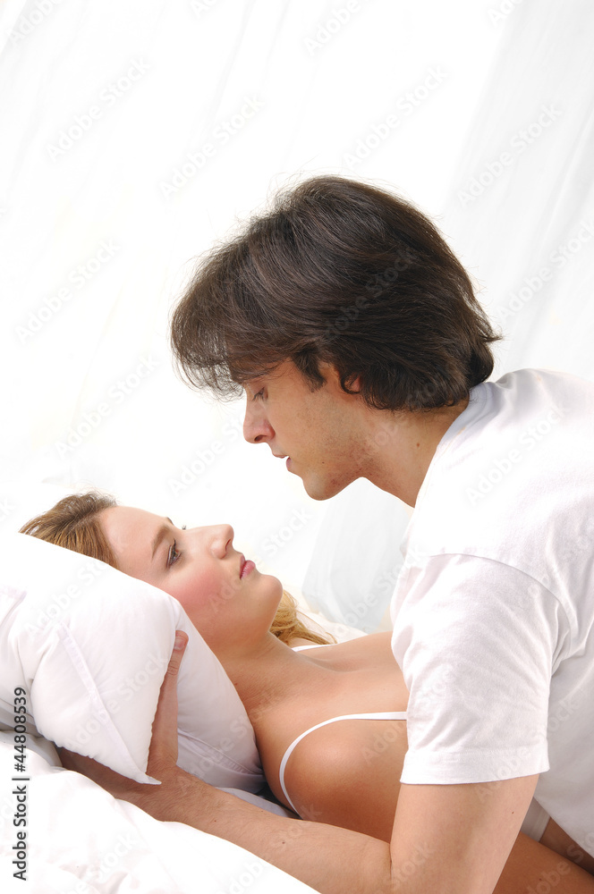 Young couple embracing in bed. A sensual and cute couple. Young couple embracing in bed. A sensual and cute couple.
