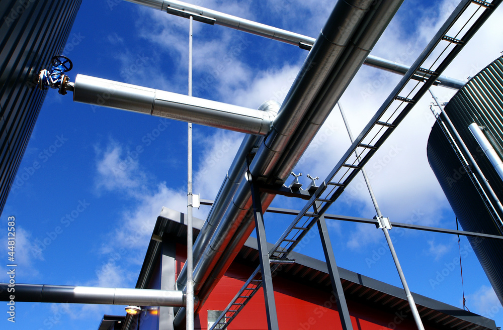 Industrial zone, Steel pipelines and valves against blue sky Industrial zone, Steel pipelines and valves against blue sky