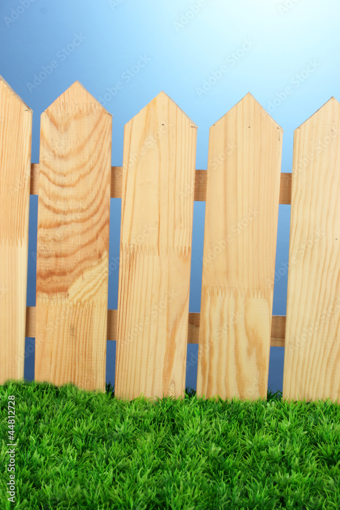 A wooden fence on a blue background close-up A wooden fence on a blue background close-up