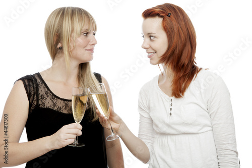 young red and blond haired girls with two glass champagne