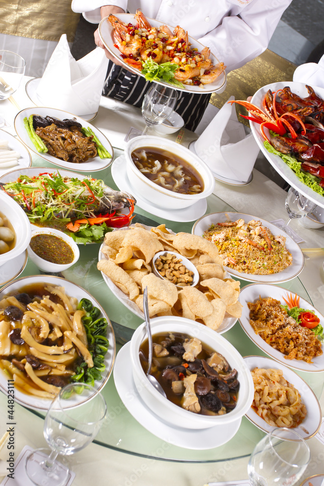 mixed Chinese food with chef holding some dishes