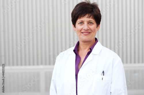 Smiling mature professional woman dressed in labcoat