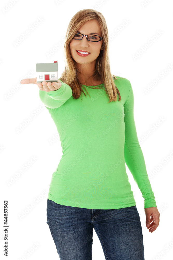 Young casual woman holding house model Young casual woman holding house model