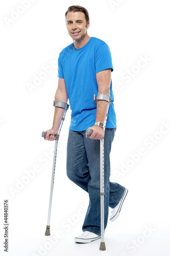 Tablou canvas Young man with crutches trying to walk