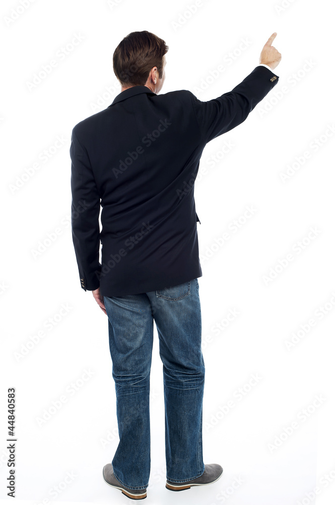 Back pose casual guy pointing at the copy space area Back pose casual guy pointing at the copy space area