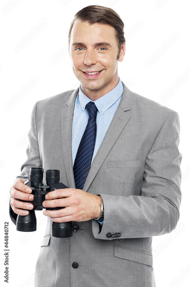 Fototapeta premium Smiling male consultant holding binoculars