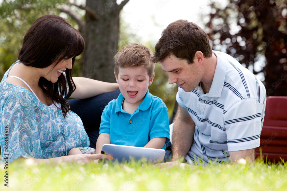 Fototapeta premium Family in Park with Digital Tablet