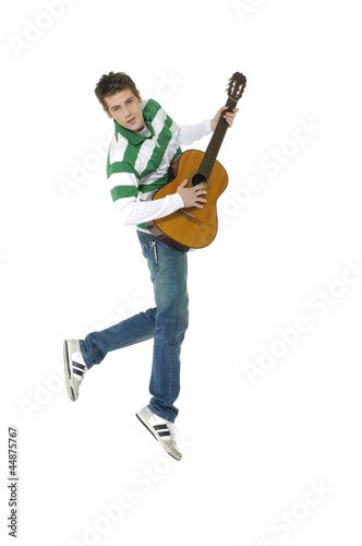 casual young man jumping with guitar