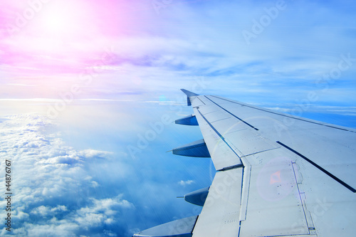 Wing of an airplane flying above the clouds