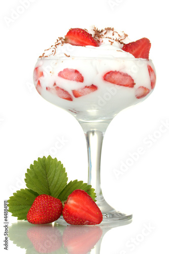 glass of ripe strawberries with cream isolated on white photo