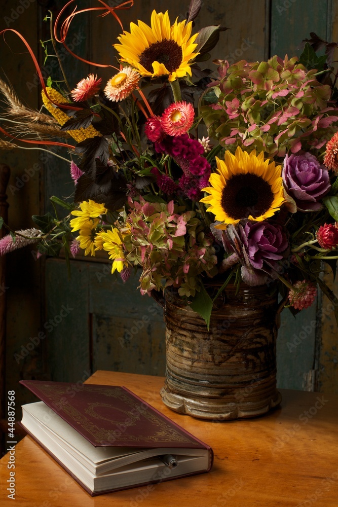 Obraz premium Rustic still life with autumn flowers and leather bound book