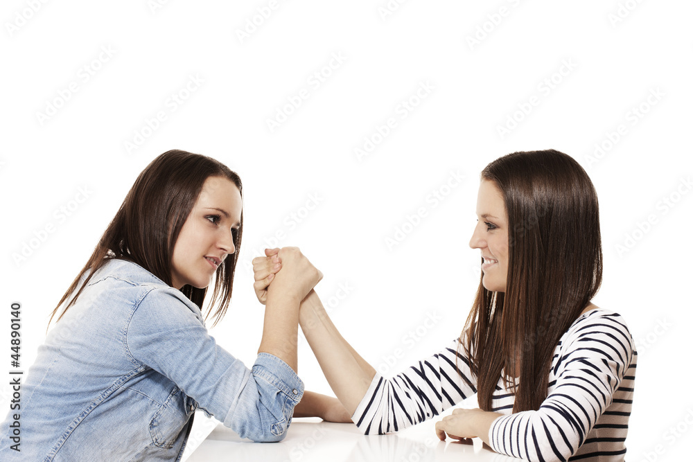mädchen beim armdrücken vor weissem hintergrund mädchen beim armdrücken vor weissem hintergrund