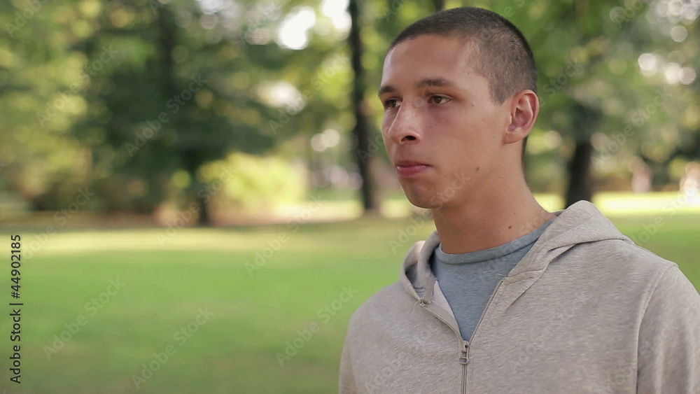 Young happy man eating apple in the park, steadicam shot Young happy man eating apple in the park, steadicam shot