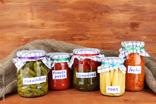 Jars with canned vegetables on green background close-up