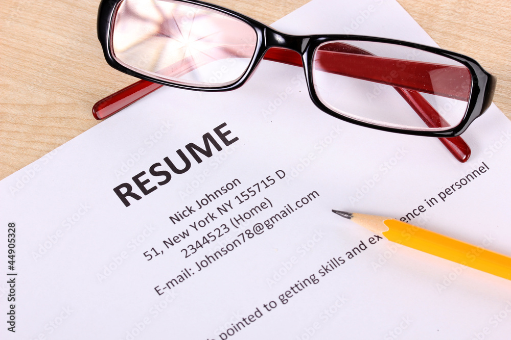 Closeup of resume with pencil and glasses on table Closeup of resume with pencil and glasses on table