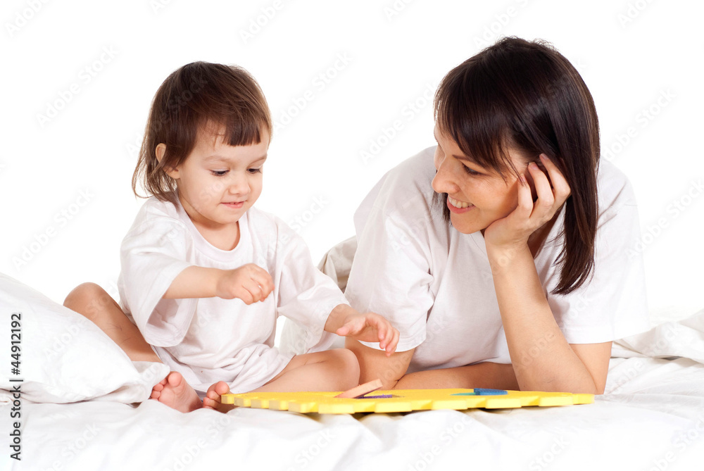A beautiful Caucasian mother with her daughter play with a mat A beautiful Caucasian mother with her daughter play with a mat