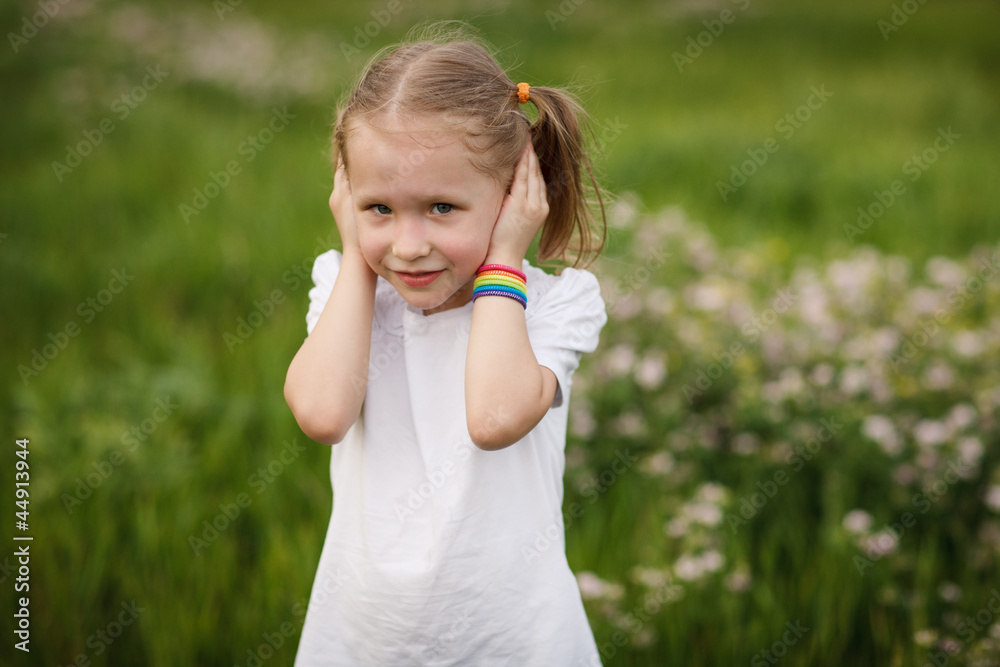 Hear no evil ,little girl covering her ears with hands, outdoors Hear no evil ,little girl covering her ears with hands, outdoors