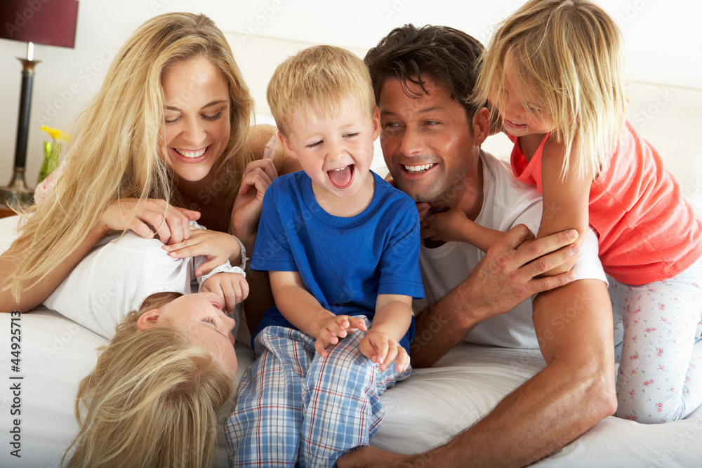 Family Relaxing Together In Bed
