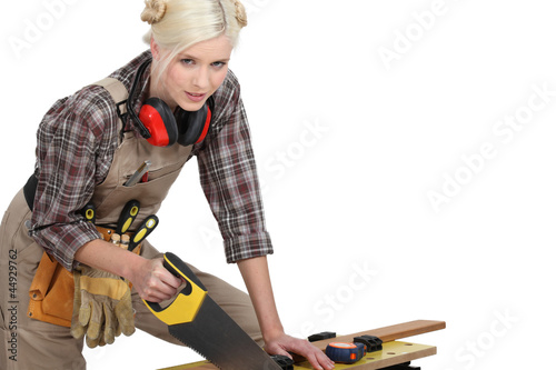 A female carpenter sawing. photo