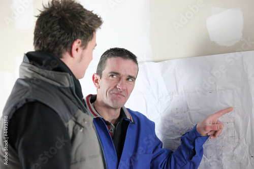 Builder pointing to wall
