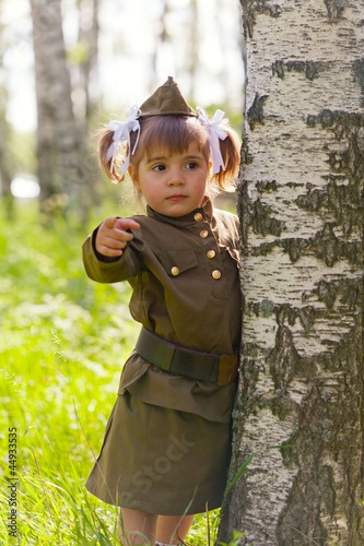 little girl in a military uniform against planes