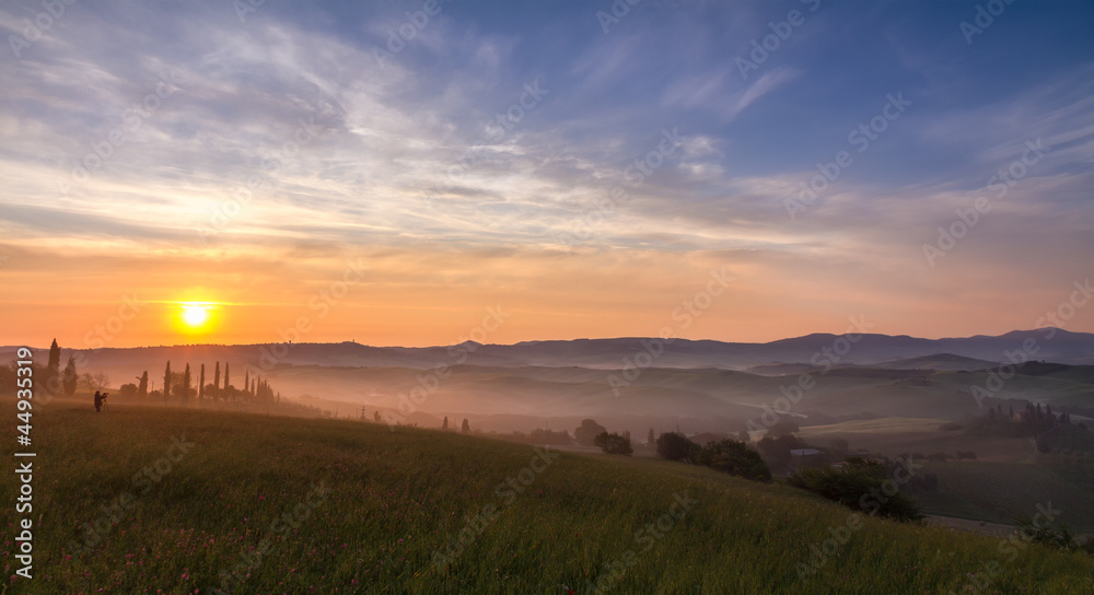 Val d'Orcia after sunrise with photographer, Tuscany, Italy