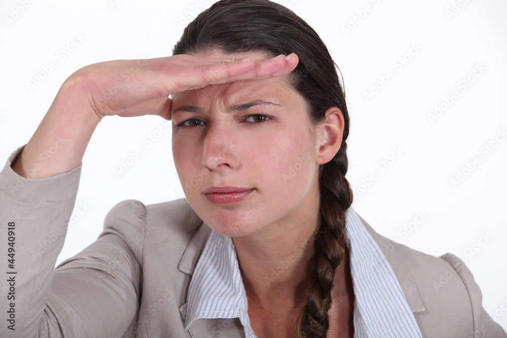 Brunette businesswoman saluting