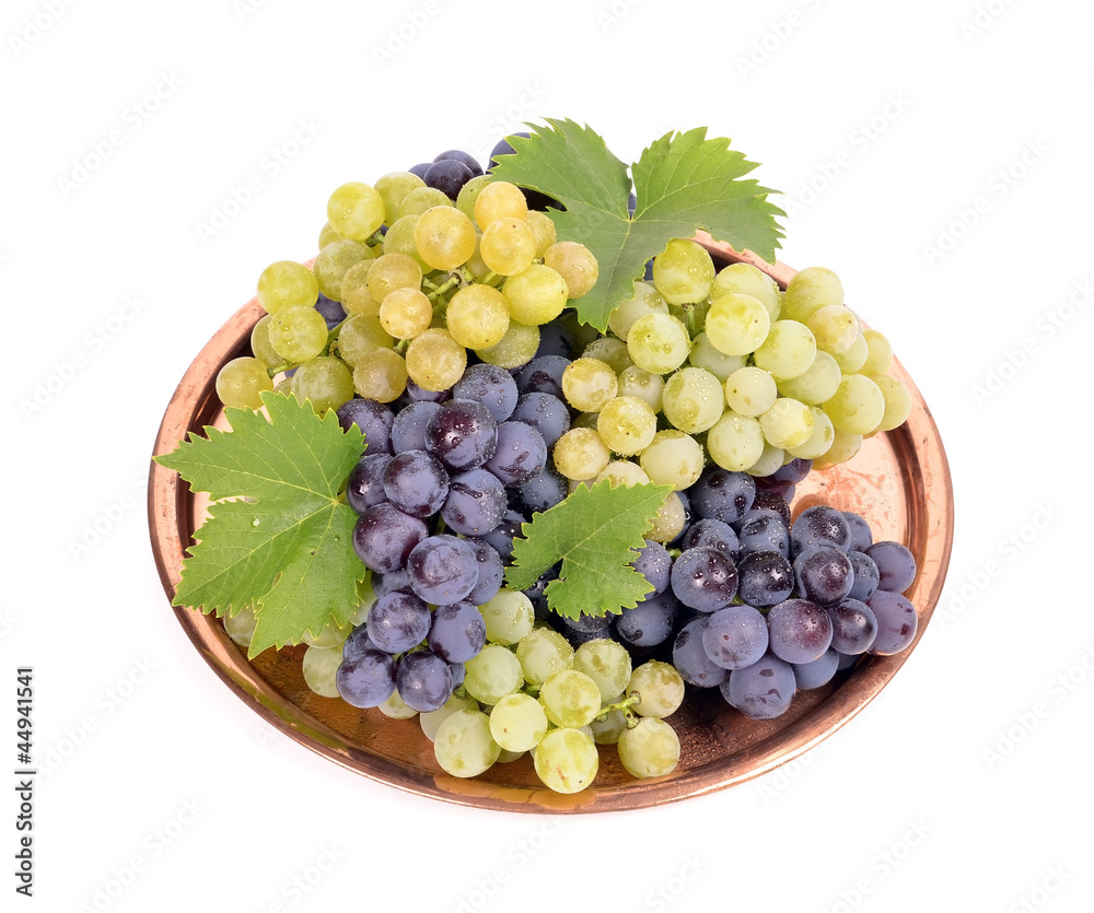 Fototapeta premium Black and white grapes in a metal bowl isolated ,drops