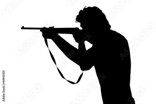 A silhouette of a man shooting with a rifle