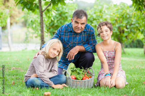 Adult Farmer with Children and Harvested Vegetables