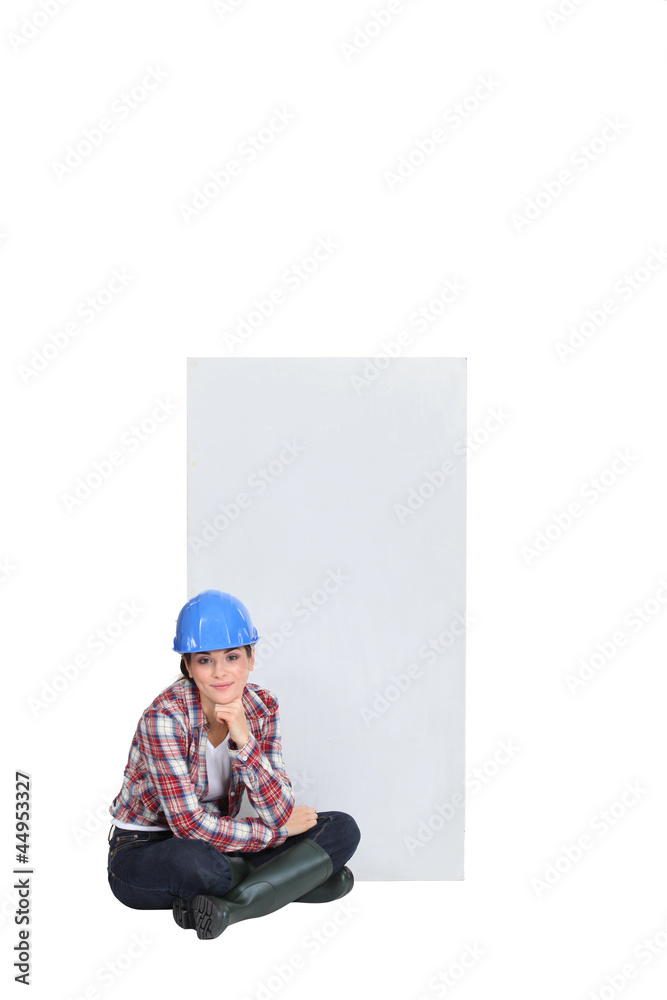 Female construction worker sat on the floor thinking Female construction worker sat on the floor thinking