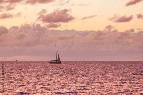 A solitary sailboat in the open sea © romantsubin