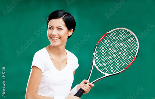 Portrait of female tennis player with racquet at the court