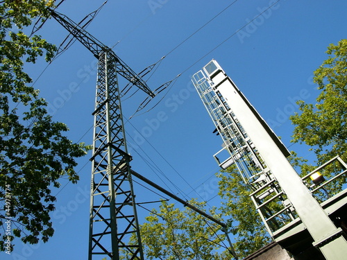 Oberleitungsmast an der Bahntrasse im Westend vor blauem Himmel im Sonnenschein in Offenbach am Main in Hessen photo