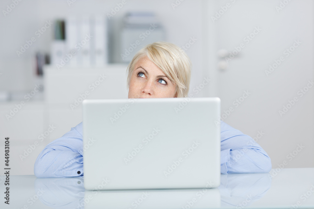junge frau schaut nachdenklich über ihren laptop junge frau schaut nachdenklich über ihren laptop
