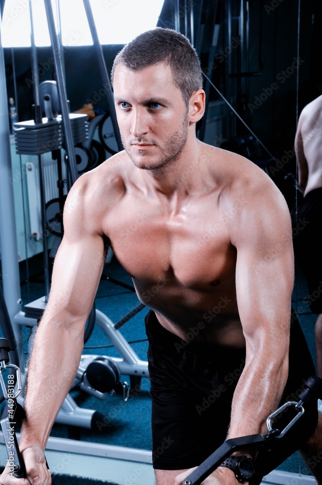 Muscular man exercising in a gym