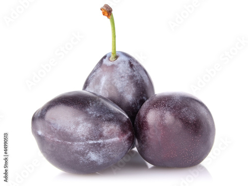ripe juicy plum with green leaf