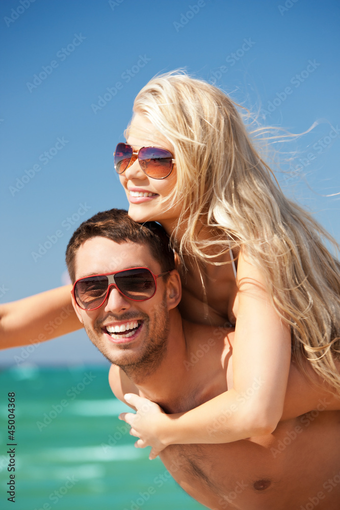 happy couple in sunglasses on the beach