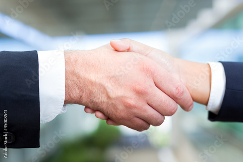 Man and woman shaking hands in office environment