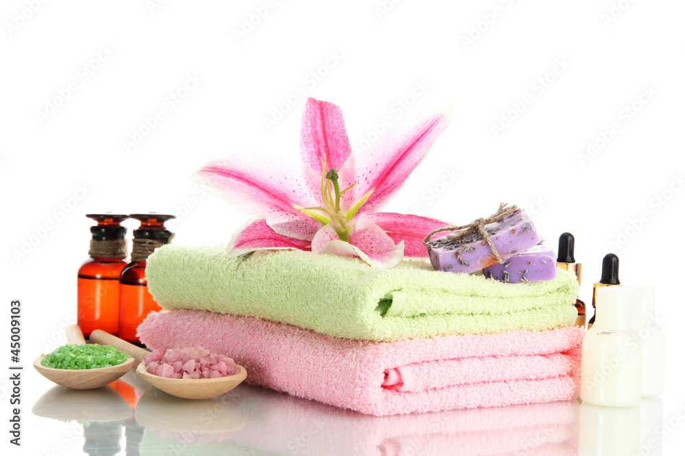 towels with lily, aroma oil, soap and sea salt isolated on towels with lily, aroma oil, soap and sea salt isolated on
