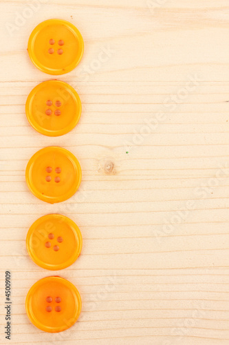Colorful sewing buttons on wooden background