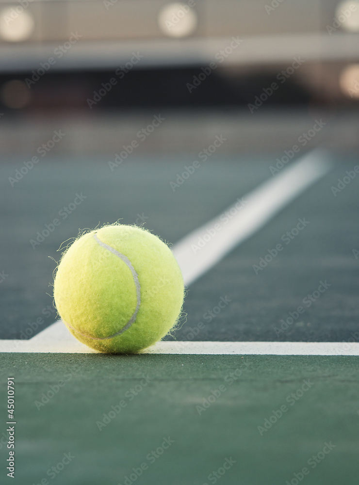 Tennis ball on line with net in background