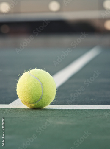 Tennis ball on line with net in background © BCFC