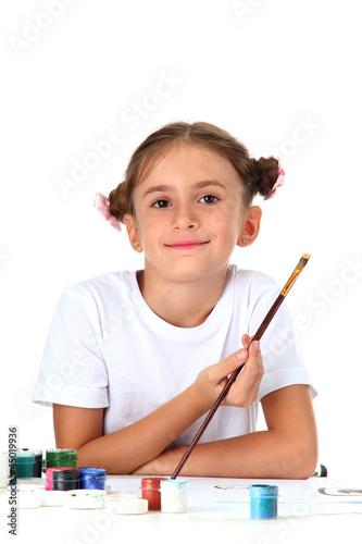 Cute little girl painting a...