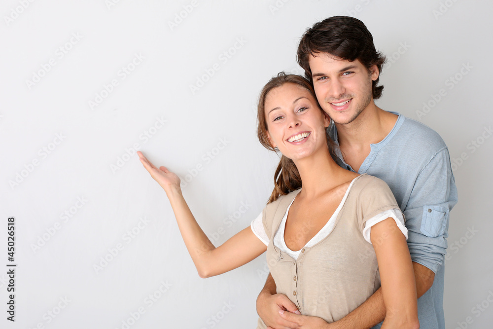Young couple on white background designating message Young couple on white background designating message