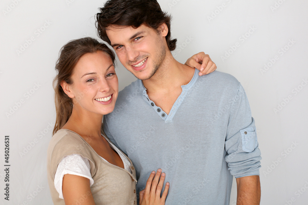 Cheerful young couple standing on white background, isolated Cheerful young couple standing on white background, isolated
