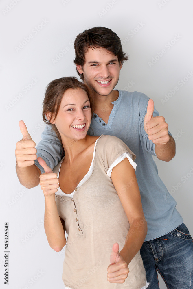 Cheerful couple showing thumbs up, isolated Cheerful couple showing thumbs up, isolated